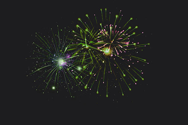 istock Vibrant Green and Purple Fireworks Burst Against Dark Sky 2251840885