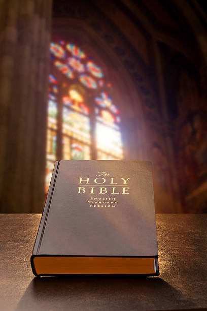 Holy Bible placed inside a church with glowing stained glass and soft sunlight streaming through.
