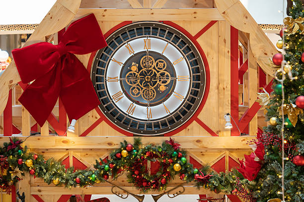 istock A rustic wooden display features a large clock surrounded by Christmas garlands, twinkling lights, and a bold red bow, creating a warm holiday centerpiece ideal for festive celebrations. 2251844240