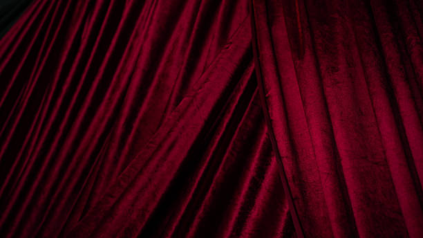 istock Luxurious red velvet fabric drapes elegantly, showcasing rich texture and depth. folds create sense of movement, perfect for adding touch of sophistication to any setting 2251844866