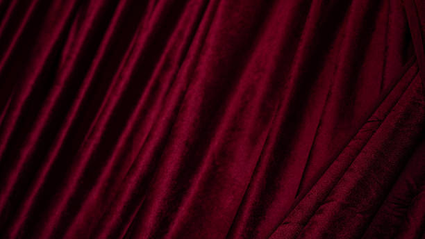 istock Luxurious red velvet fabric with rich texture and deep color, creating elegant and sophisticated appearance. soft drapes enhance visual appeal, perfect for various design applications 2251844897