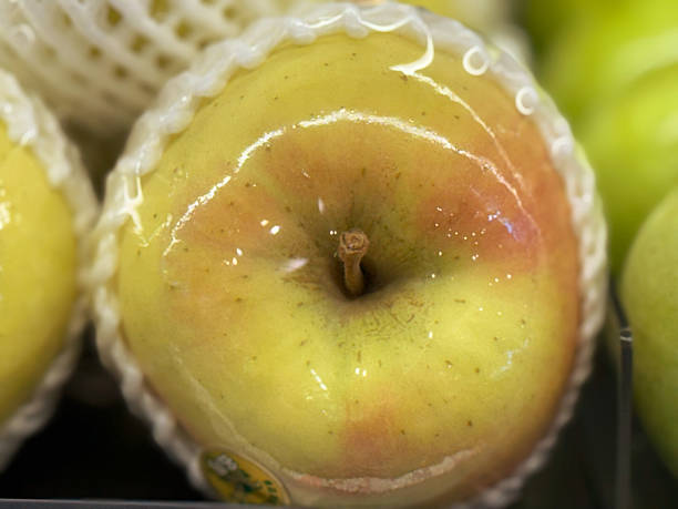 Close up of apples in plastic packaging on a shelf in the supermarket