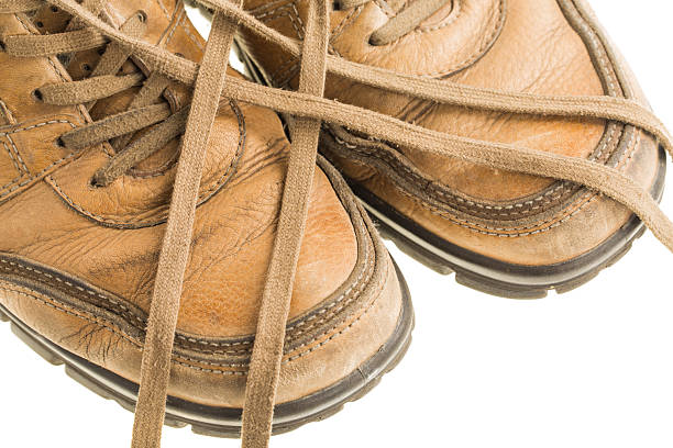 Closeup of old leather boot with crossed laces. Isolated on a white background.
