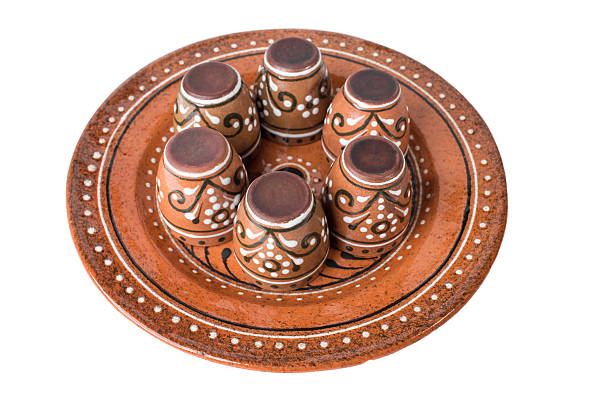 Ceramic plate with set of varnished cups. Isolated on a white background.