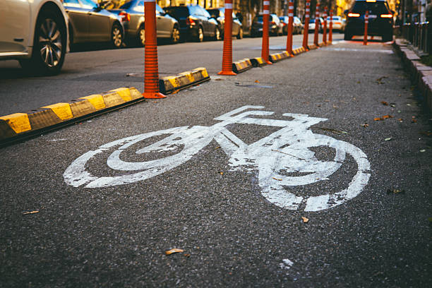 istock Urban ecology solution. Dedicated bicycle lane with clear road markings and barriers, symbolizing sustainable transport, green mobility, and healthy city living. Bicycle symbol marking on asphalt. 2251848603