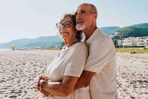istock Senior couple embracing on a sunny beach vacation 2251848669