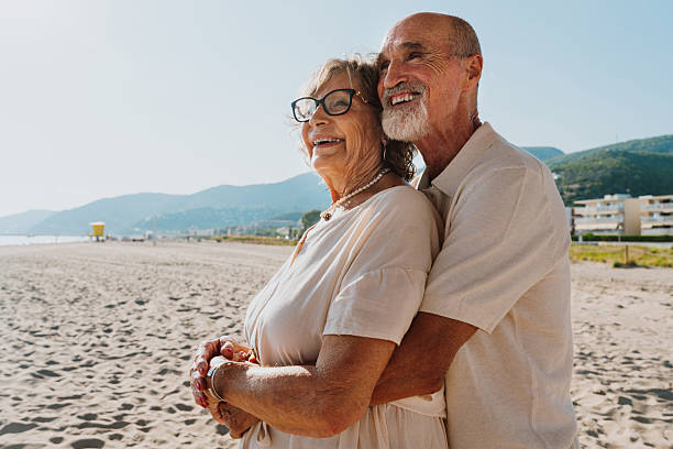 istock Senior couple embracing on a sunny beach vacation 2251848682