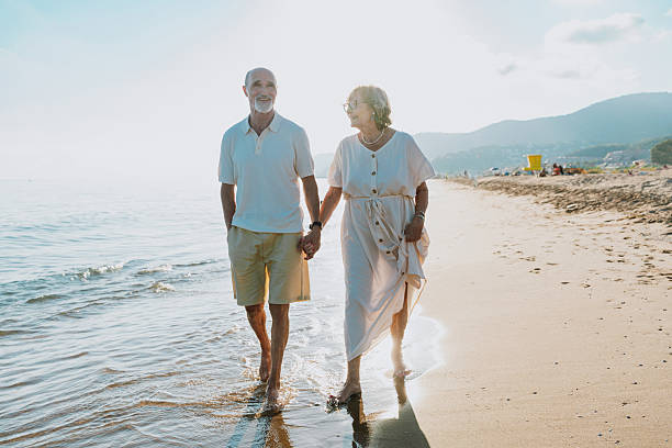 istock Senior couple walking on beach holding hands during vacation 2251848857