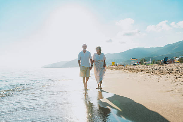istock Senior couple walking on beach holding hands during vacation 2251848888
