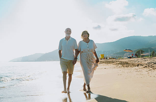 istock Senior couple walking on beach holding hands during vacation 2251848894