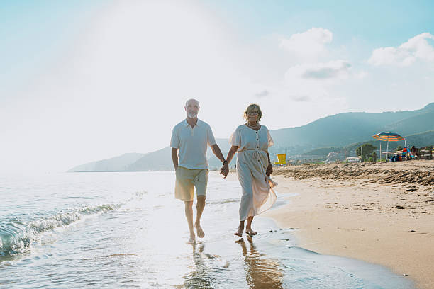 istock Senior couple walking on beach holding hands during vacation 2251848898