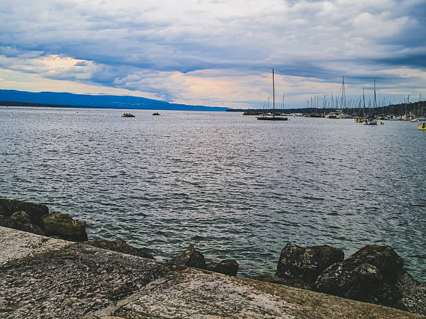 Dramatic cloudy sky over a calm harbor with sailing boats.