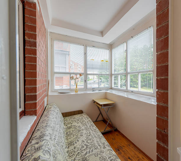 istock Cozy Indoor Balcony Sitting Area with Large Windows and Brick Wall 2251849728