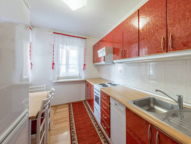 istock Cozy Kitchen With Red Accents and Natural Light Entering Through Curtains 2251849737
