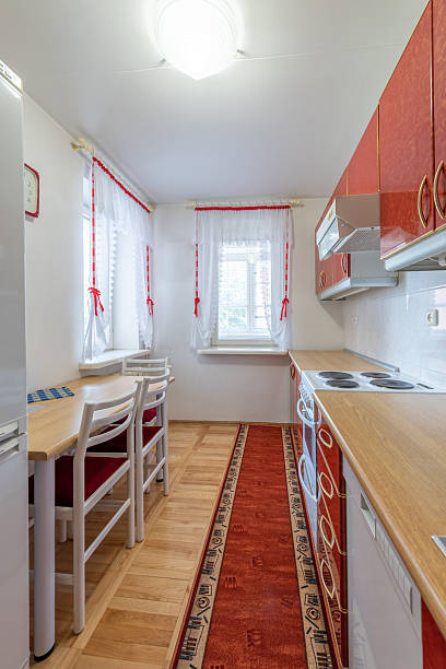 istock Cozy Kitchen With Red Accents and Natural Light Entering Through Curtains 2251849823