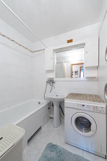 istock Compact Modern Bathroom with Washing Machine and Clean White Tiles 2251849828