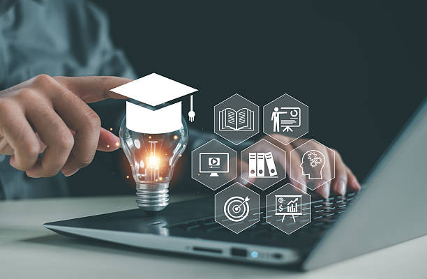 istock Hand touching glowing light bulb with graduation cap above laptop, representing online education, digital learning platform, training technology and smart education innovation concept. 2251850531