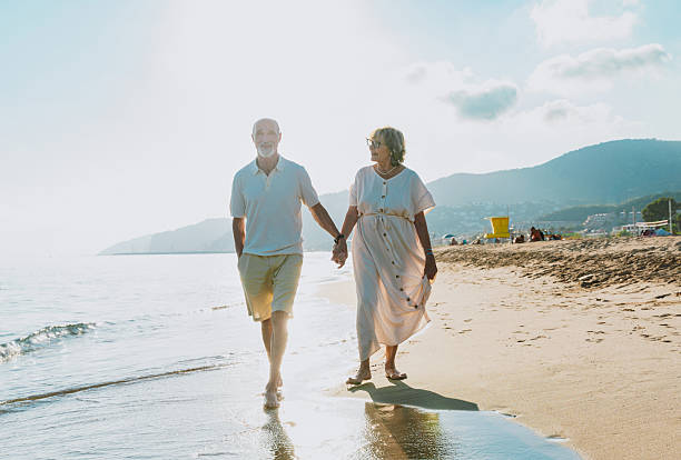 istock Senior couple walking on beach holding hands during vacation 2251853802