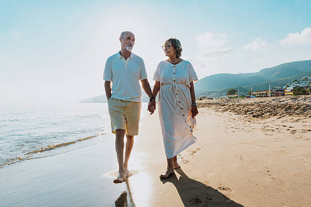 istock Senior couple walking on beach holding hands during vacation 2251853807