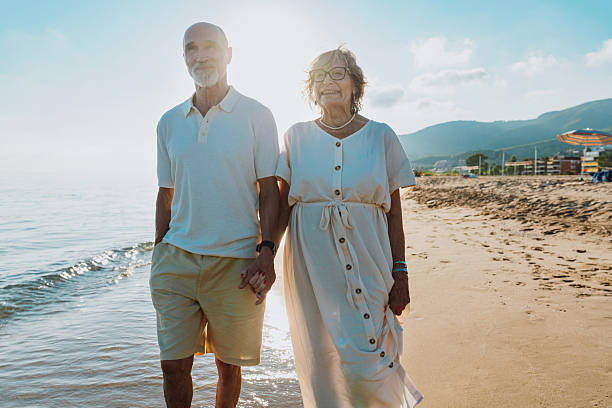 istock Senior couple walking on beach holding hands during vacation 2251853820