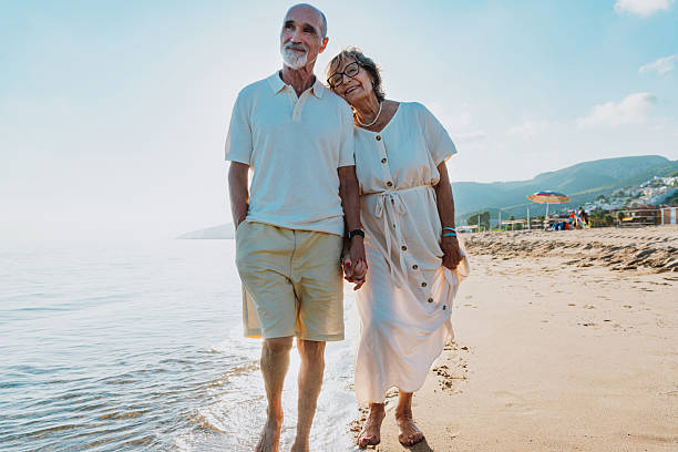 istock Senior couple walking on beach holding hands during vacation 2251853823