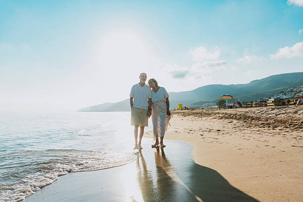 istock Senior couple walking on beach holding hands during vacation 2251853829