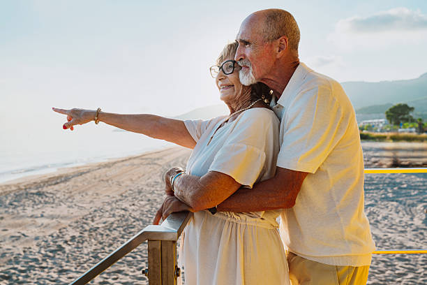 istock Happy senior couple enjoying sunset on beach pointing 2251853986