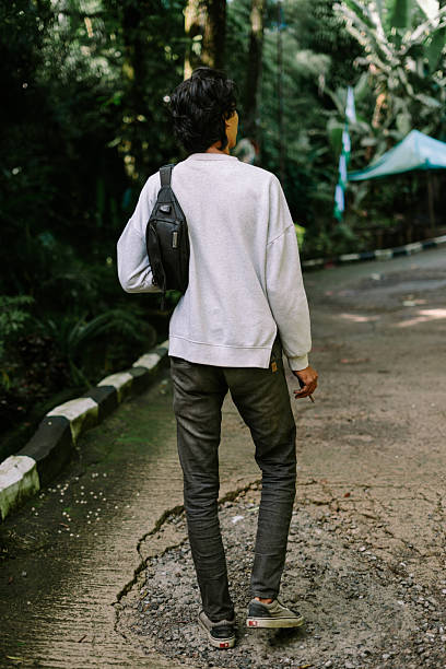 istock Young man walking on a cracked forest path with green trees 2251864730