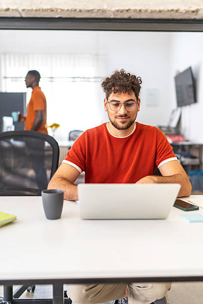 istock Young man working on laptop in modern office 2251875103