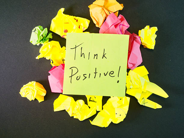 istock Think Positive! Note Amidst Crumpled Papers - An uplifting 'Think Positive!' sticky note surrounded by colorful crumpled papers on a dark background, symbolizing idea generation, challenges, and resilience. 2251876505