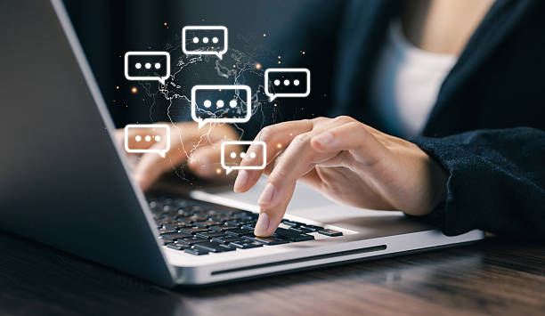 istock Hands typing on a laptop with floating chat bubbles over a world map, representing global online communication, instant messaging, remote collaboration, and digital business interaction. 2251883775