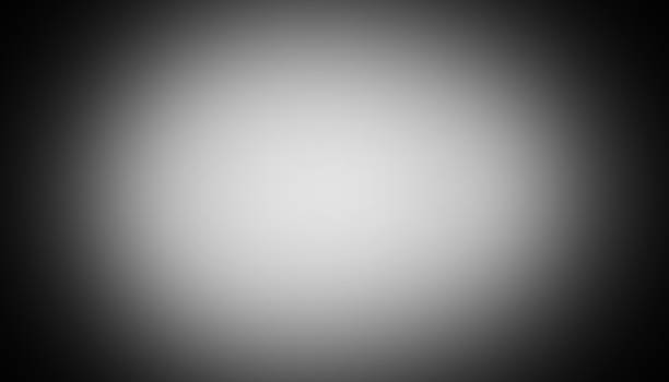 istock Black and white radial vignette gradient background. Central light glow. Soft blurred edges. Subtle noise grain texture. Smooth grayscale fade. Minimal monochrome light burst effect. PNG 2251883782