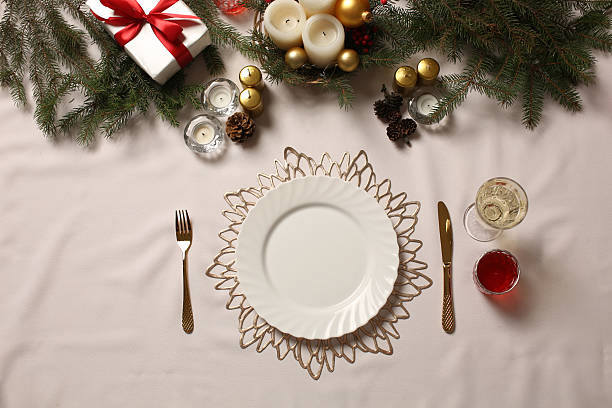 istock Christmas table setting with white plate, candles, pine branches and festive decorations 2251884411
