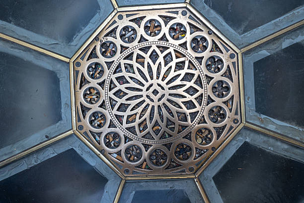 MILAN, ITALY, 06.19.2025:An ornate metal grate forms a circular floral mandala at the center of an octagonal ceiling panel, blending architectural detail with geometric symmetry and timeless craftsmanship. This decorative cover is in the Galleria Vittorio Emanuele II in Milan.