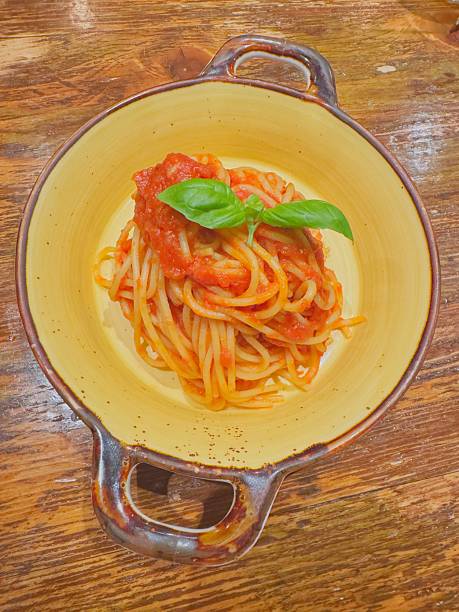 Main dish of spaghetti with a simple tomato  sauce garnished with basil