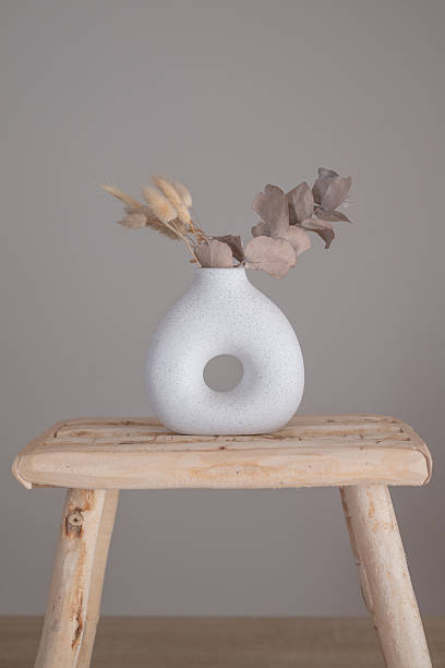 istock Ceramic vase and wooden stool in a neutral interior 2251894031