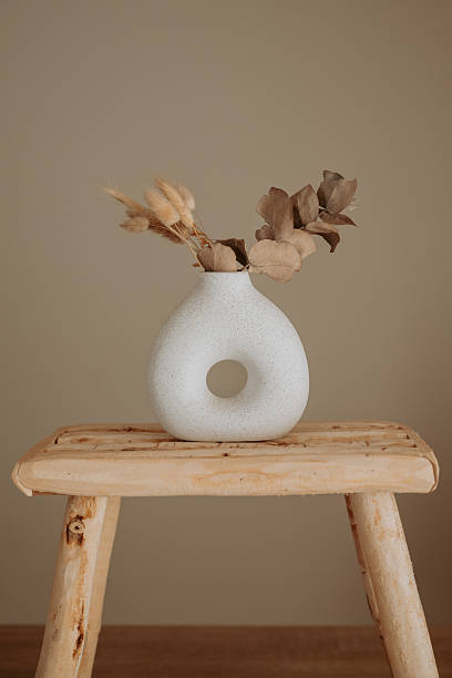 istock Ceramic vase and wooden stool in a neutral interior 2251894049
