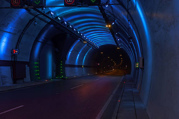 istock The vast, dark highway tunnel is strikingly illuminated by bright blue modern LED lights. 2251895617