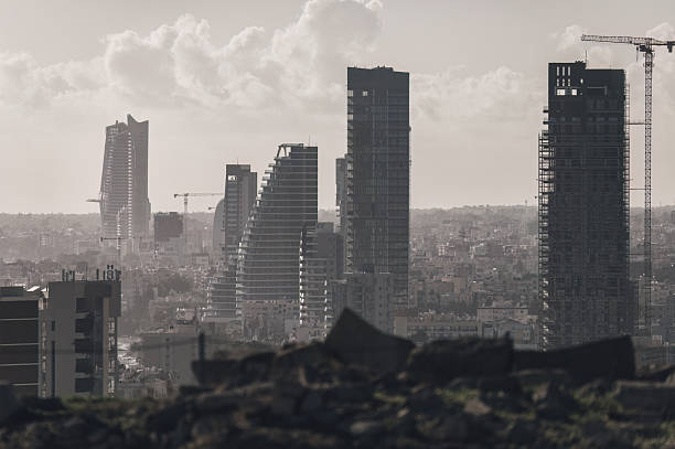 Construction cranes towering over Limassol city skyline with hazy sky. Cyprus