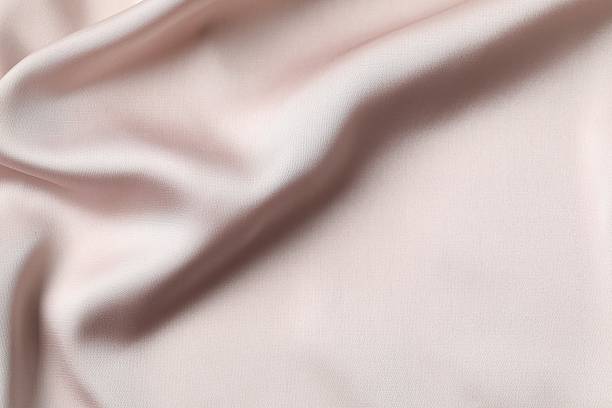 istock Beige silk satin. Shiny smooth fabric. Soft folds. Luxury background with space for design. Flat table, top view 2251902173