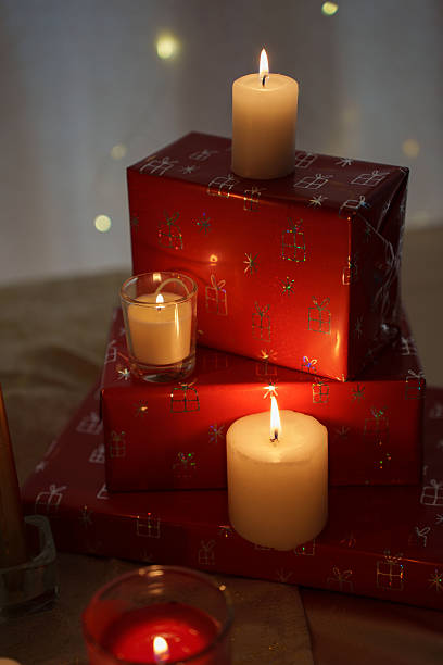 istock elegant holiday scene with festive red gift boxes adorned with glowing candles, creating a warm, cozy atmosphere with soft bokeh lights in the background, whimsical, illuminated, hue, lightness 2251902358