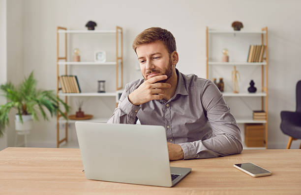 istock Young business man working on a laptop at office or at home and looking on a computer screen. 2251904319