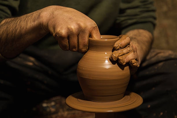 Hands of a potter, creating an earthen jar