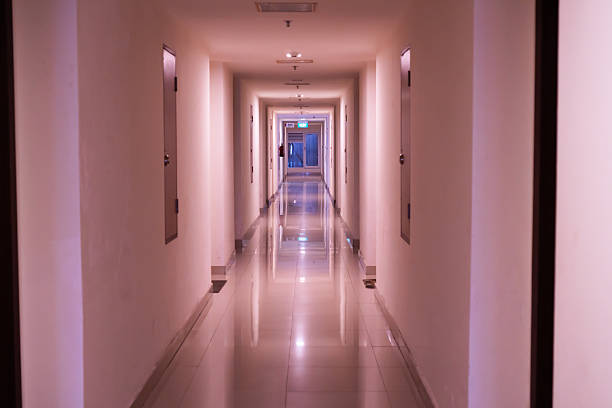 Long Hotel Corridor With Reflections and Arched Doorways Illuminated by Soft Warm Lighting