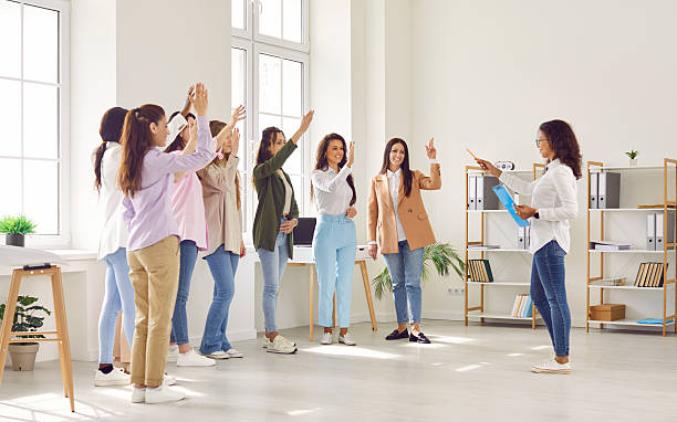 istock Happy motivated employees raising hands asking coach or voting at training 2251910854