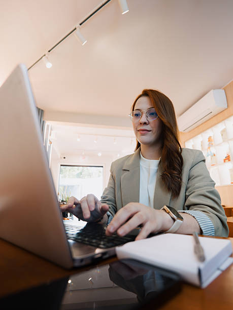 istock Businesswoman typing on laptop during remote work session in cafe 2251911601