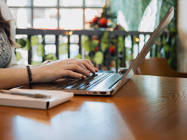 istock Female hands using laptop on wooden table in cafe workspace 2251912801