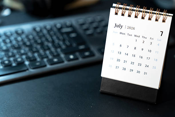 istock A tabletop calendar displaying July 2026 with a spiral binding, positioned beside a computer keyboard. The calendar highlights the days, offering a clear visual of time management. 2251914191