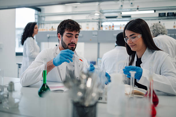 istock Young scientists conducting experiment in modern chemistry lab 2251917712