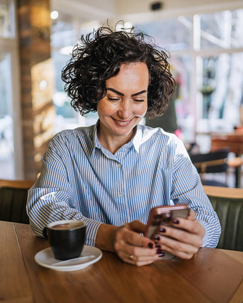istock Woman relaxing in a cafe scrolling on smart phone 2251918193